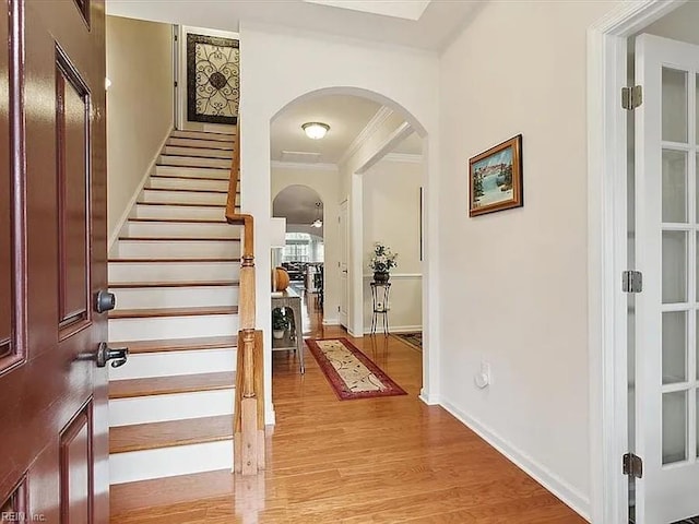 entryway with light hardwood / wood-style flooring and ornamental molding