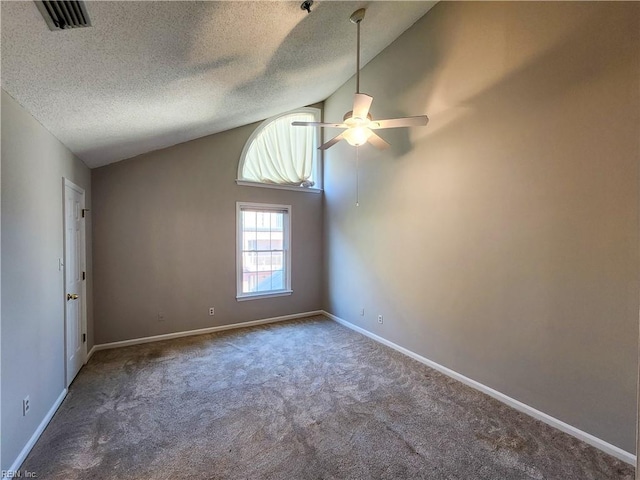 carpeted empty room with high vaulted ceiling and a textured ceiling