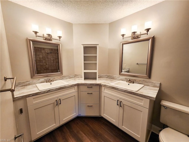 bathroom featuring hardwood / wood-style flooring, a textured ceiling, toilet, and vanity