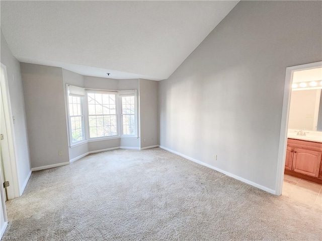 carpeted empty room with lofted ceiling