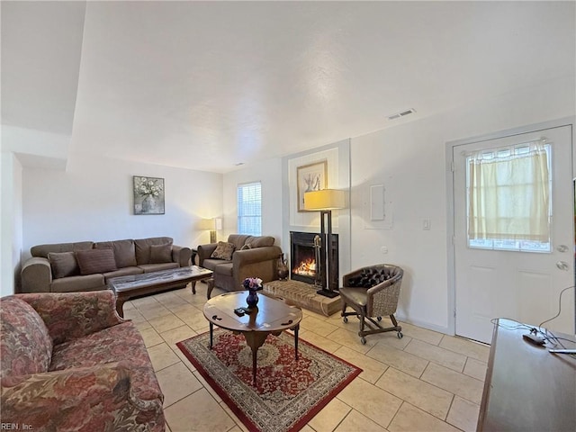 living room with light tile patterned flooring and a fireplace