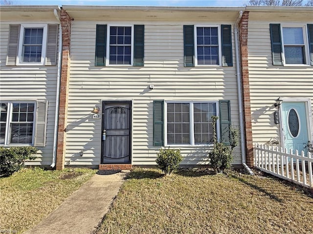 townhome / multi-family property with a front yard