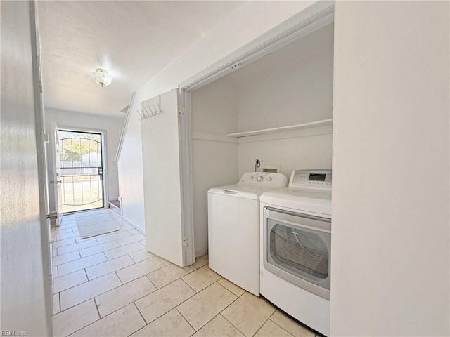 laundry area featuring washing machine and dryer and light tile patterned floors