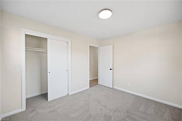 unfurnished bedroom featuring a closet and light colored carpet