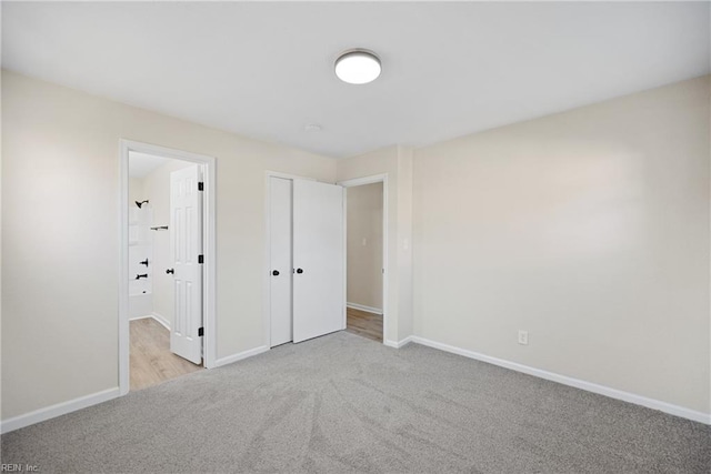 unfurnished bedroom featuring light colored carpet and a closet