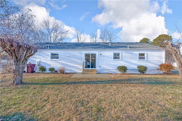 back of property featuring a lawn