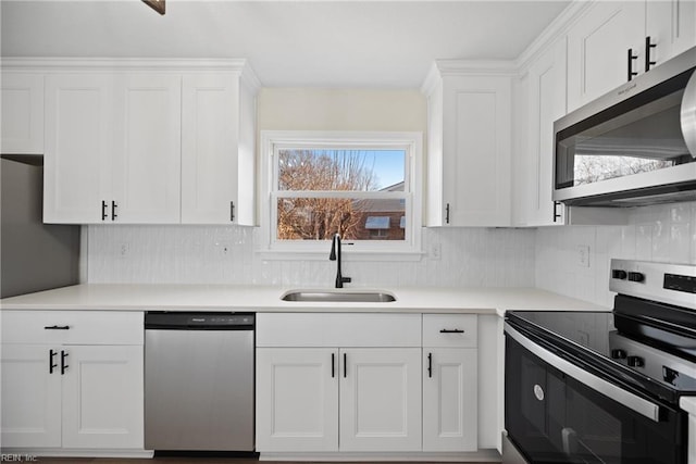 kitchen featuring appliances with stainless steel finishes, white cabinets, tasteful backsplash, and sink