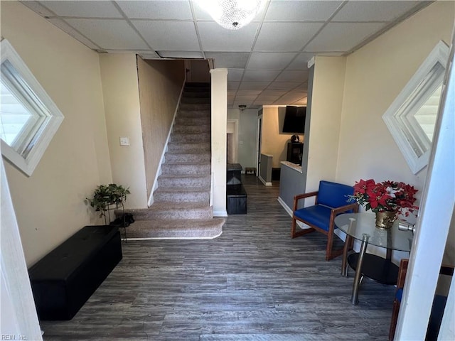 stairs featuring a drop ceiling and hardwood / wood-style flooring