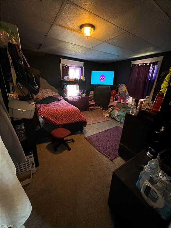 carpeted bedroom with a drop ceiling