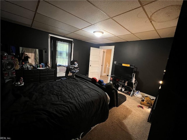 bedroom with a drop ceiling and carpet floors