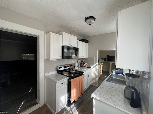 kitchen featuring a drop ceiling, electric range, decorative backsplash, and white cabinetry