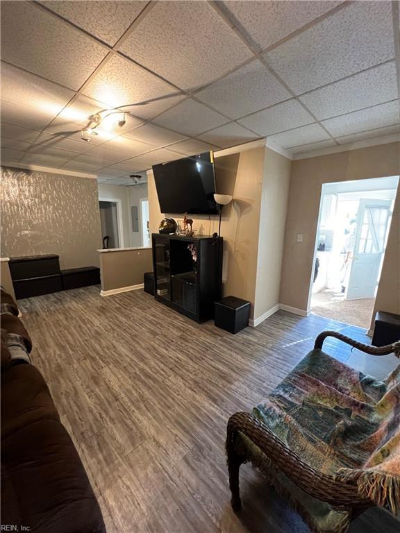 living room featuring a paneled ceiling and hardwood / wood-style flooring