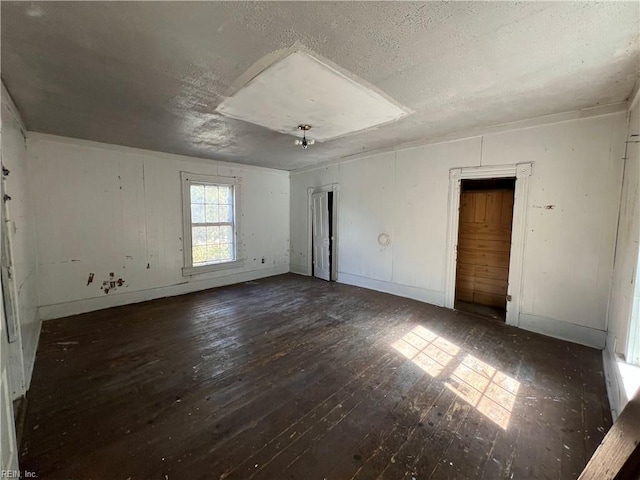 unfurnished room featuring a textured ceiling and dark hardwood / wood-style floors