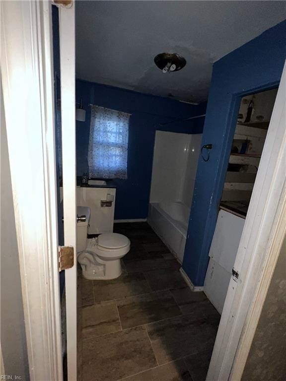 bathroom featuring tub / shower combination and toilet