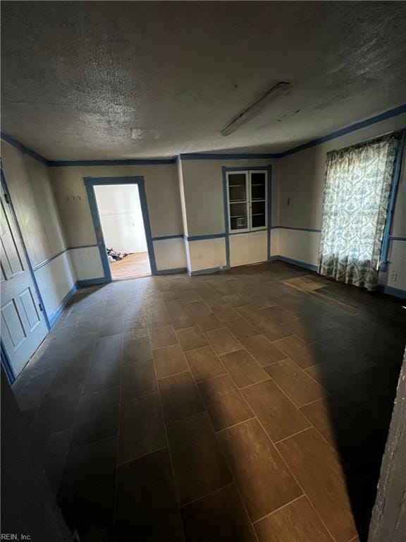 unfurnished room featuring a textured ceiling and crown molding