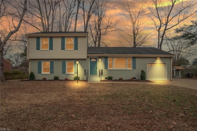 view of front of house with a garage and a lawn