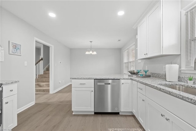 kitchen featuring white cabinetry, light hardwood / wood-style floors, kitchen peninsula, dishwasher, and hanging light fixtures