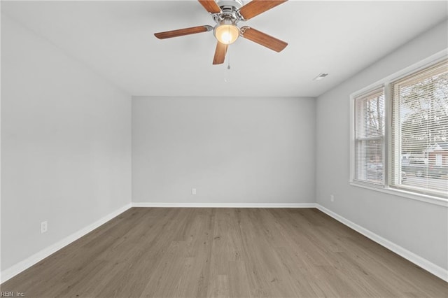 empty room with ceiling fan and light hardwood / wood-style flooring