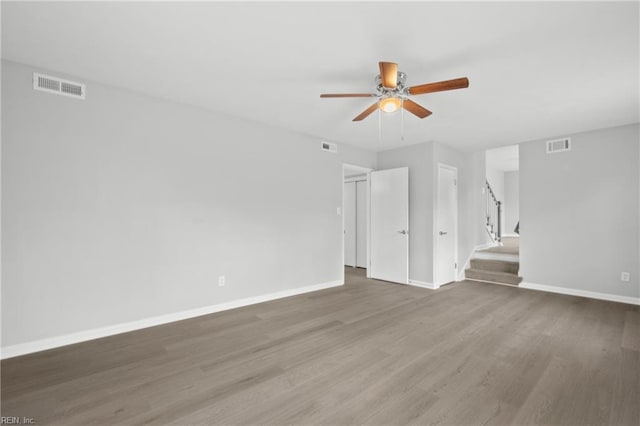 unfurnished living room with ceiling fan and dark hardwood / wood-style flooring