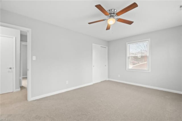 unfurnished room with ceiling fan and light carpet