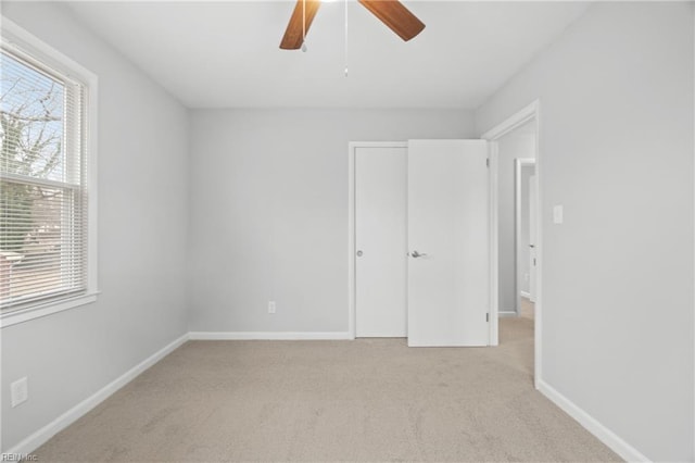 unfurnished bedroom featuring ceiling fan and light carpet