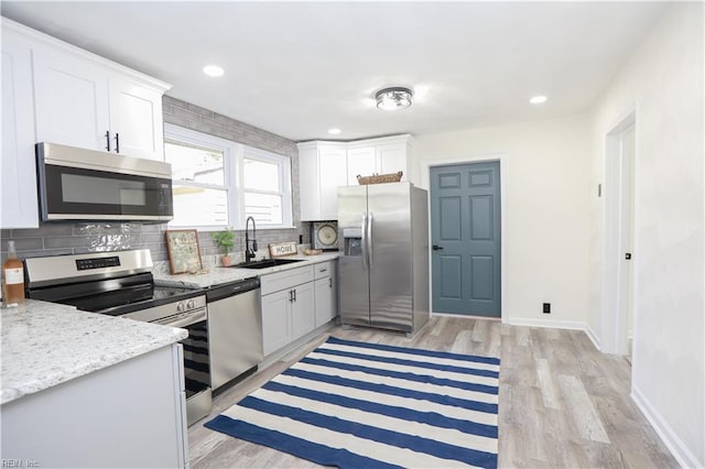 kitchen featuring appliances with stainless steel finishes, sink, and white cabinetry