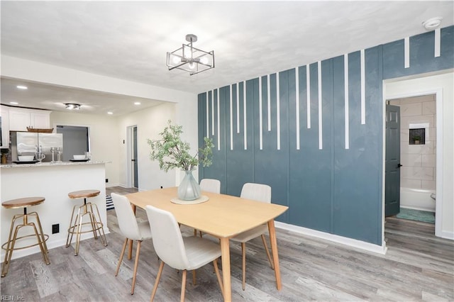 dining area featuring light hardwood / wood-style floors and a notable chandelier