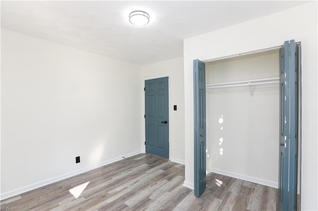 unfurnished bedroom featuring a closet and wood-type flooring