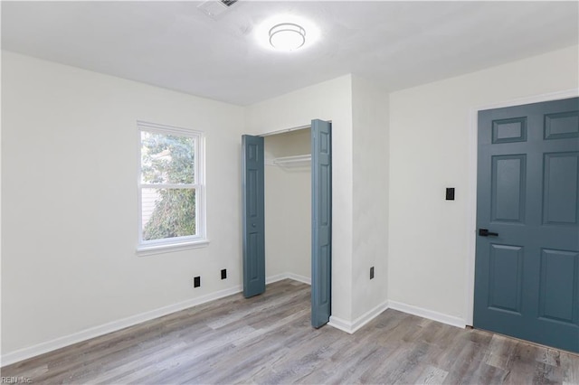 unfurnished bedroom with a closet and light hardwood / wood-style flooring