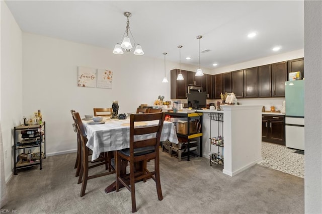 dining area featuring light carpet and a chandelier