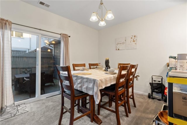 carpeted dining space with a notable chandelier