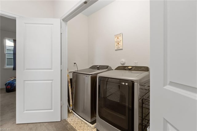 laundry room with light colored carpet and separate washer and dryer