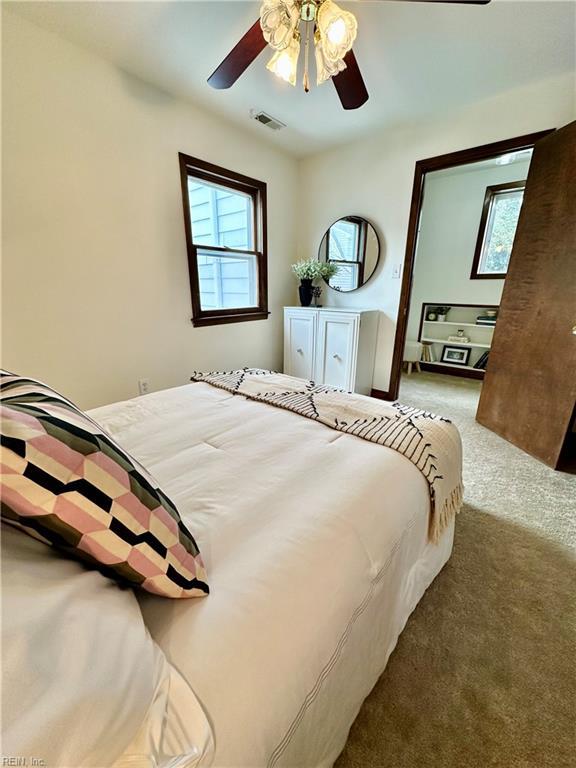 bedroom with ceiling fan, multiple windows, and carpet flooring