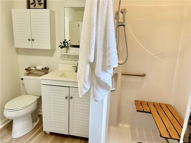 bathroom with toilet, vanity, wood-type flooring, and walk in shower