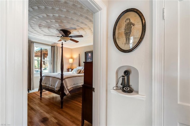 bedroom featuring ceiling fan, hardwood / wood-style flooring, and crown molding