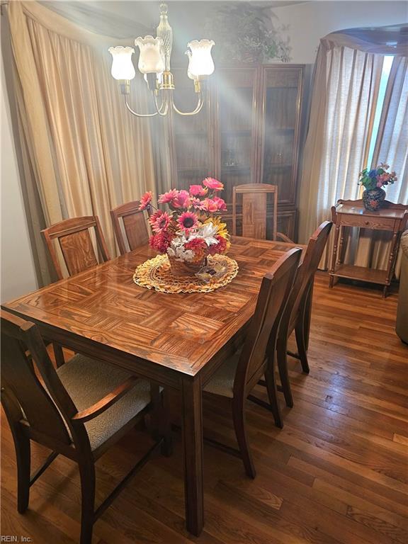 dining space with an inviting chandelier and dark hardwood / wood-style flooring