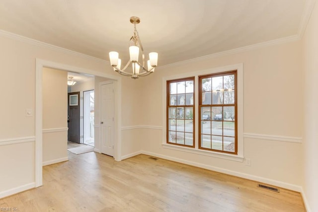 unfurnished dining area with crown molding, a chandelier, and light wood-type flooring