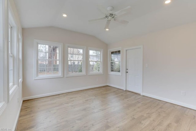 empty room featuring ceiling fan, vaulted ceiling, and light wood-type flooring