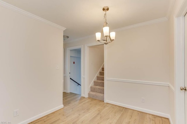 unfurnished room with light hardwood / wood-style floors, a chandelier, and ornamental molding