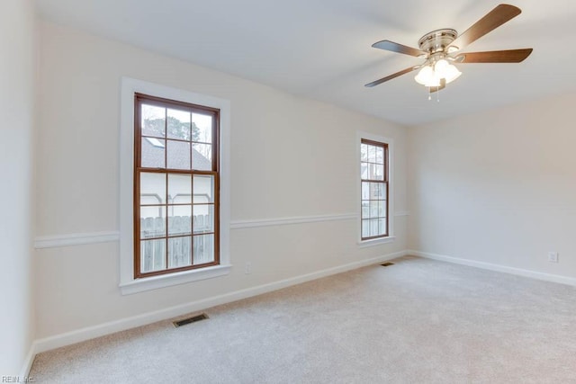 empty room featuring ceiling fan and light carpet