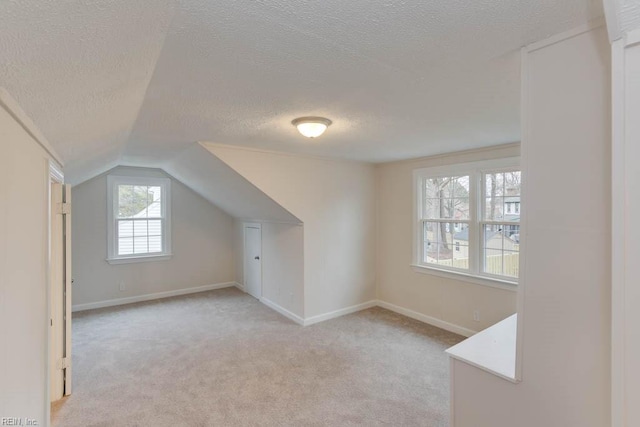 bonus room with light carpet, a textured ceiling, and lofted ceiling