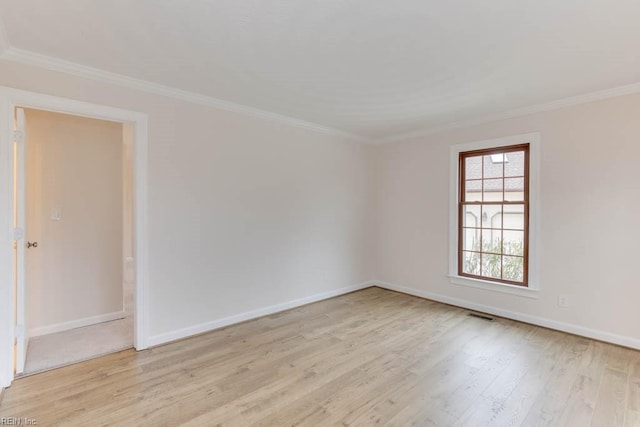 empty room featuring light hardwood / wood-style floors and ornamental molding