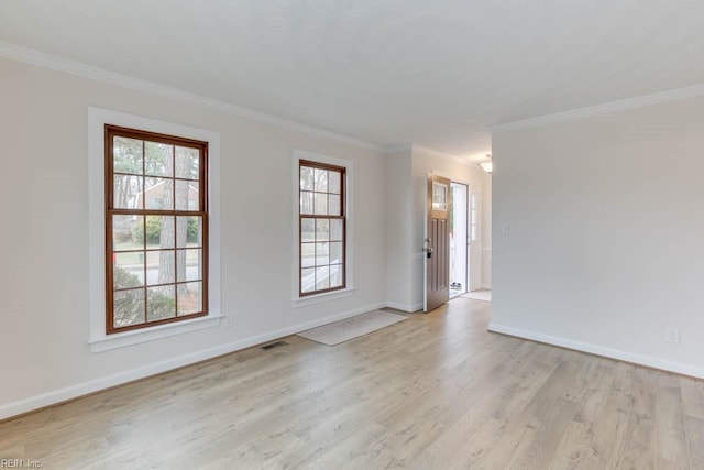 spare room with ornamental molding and light hardwood / wood-style flooring