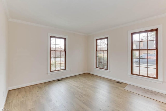 empty room with light hardwood / wood-style floors and crown molding