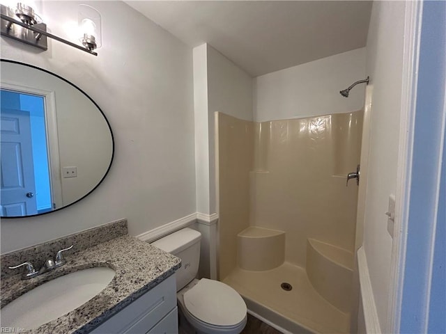 bathroom with toilet, vanity, and a shower