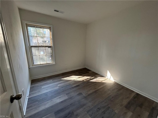 empty room with dark hardwood / wood-style flooring