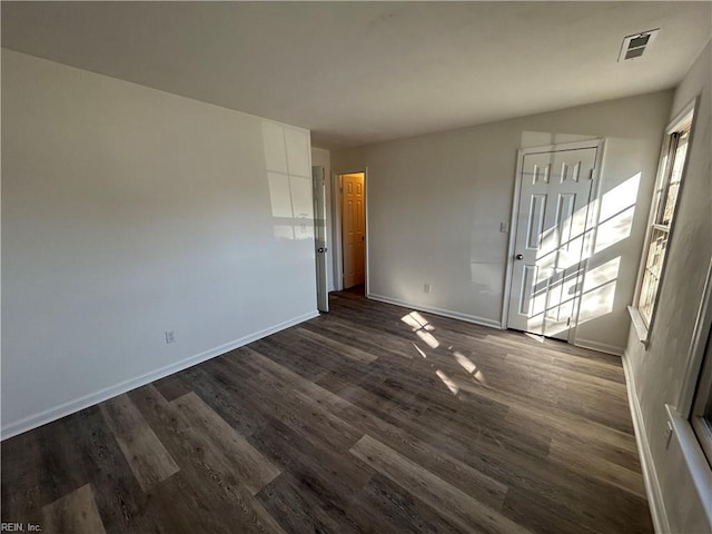 unfurnished room featuring dark hardwood / wood-style flooring and a healthy amount of sunlight