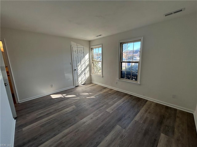 empty room with dark hardwood / wood-style flooring