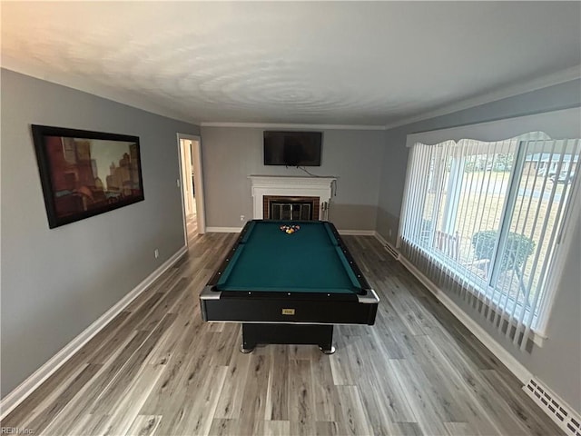 recreation room with a brick fireplace, hardwood / wood-style flooring, and billiards