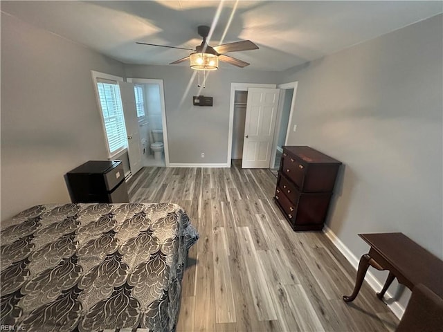 bedroom featuring ceiling fan, a closet, connected bathroom, and light hardwood / wood-style flooring